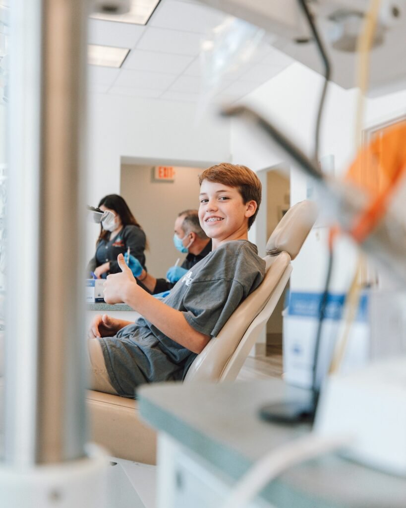 Ragazzo sorridente sulla poltrona del dentista
